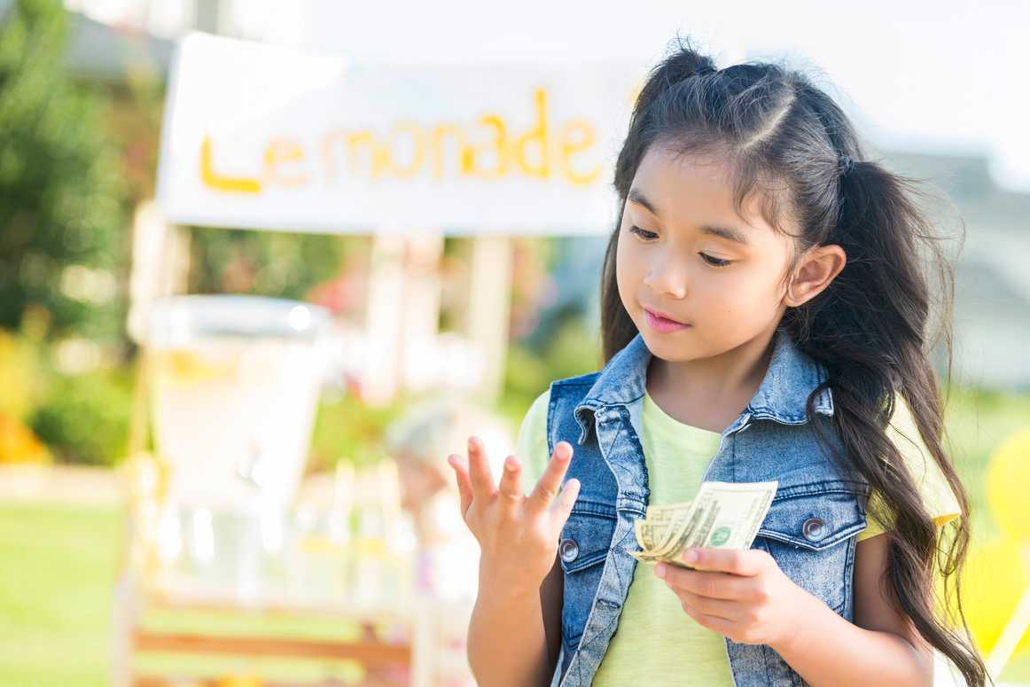 Young girl counts money made from lemonade